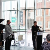 a man speaking behind a podium in front of a crowd